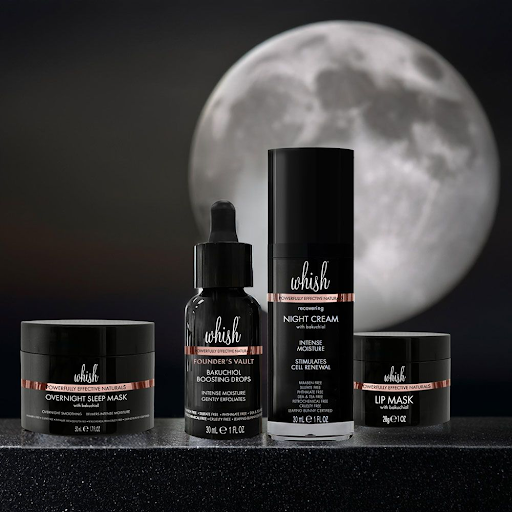 Whish nighttime skincare set with overnight mask, night cream, and lip mask placed on a dark surface under a full moon.