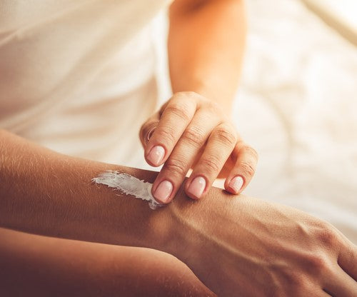 woman applying body butter to her arm